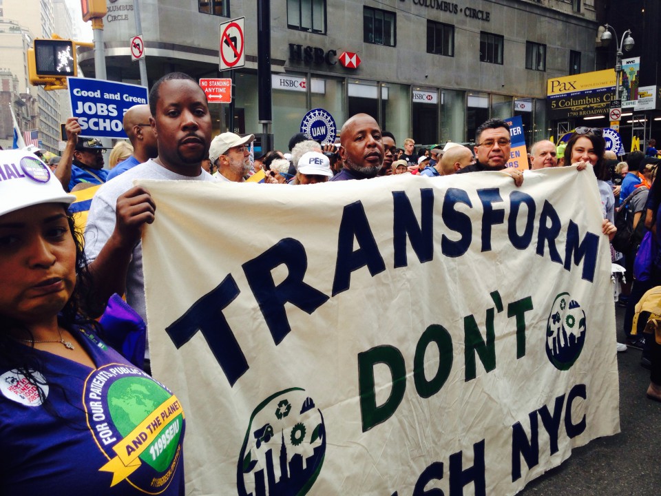 A group of TDTNYC members holding a "Transform Don't Trash NYC" sign at a rally.