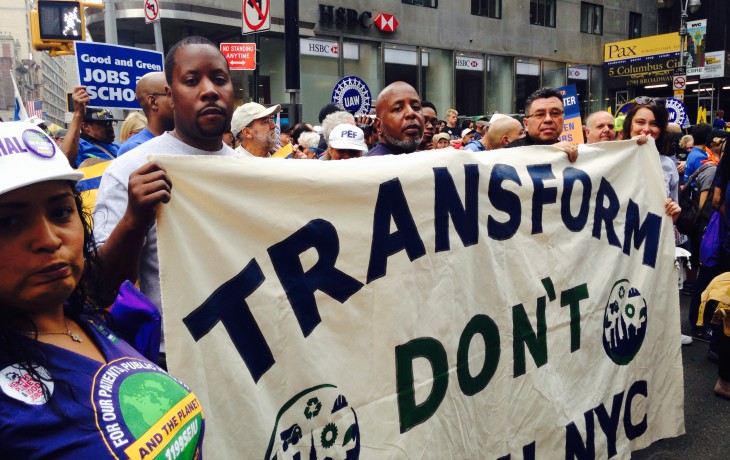 A group of TDTNYC members holding a "Transform Don't Trash NYC" sign at a rally.